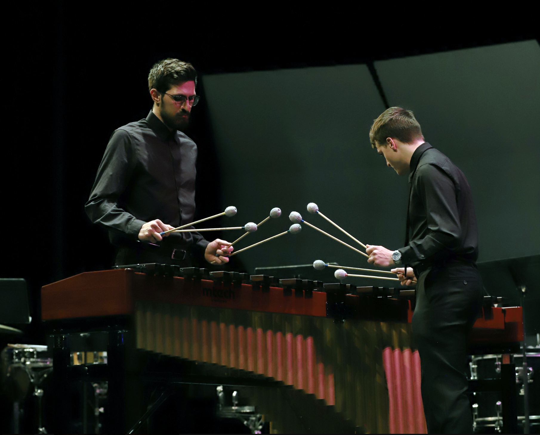 Photo of two percussionists playing the xylophone together.