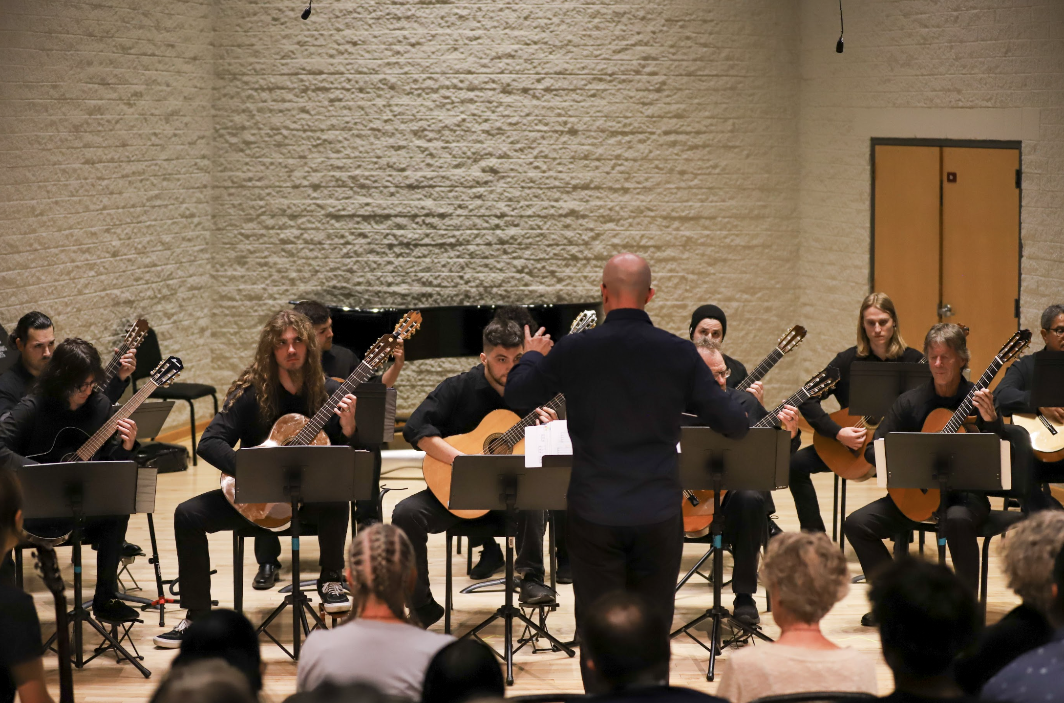 Photo of Michael Lich conducting the PCC Guitar Ensemble in the Recital Hall.