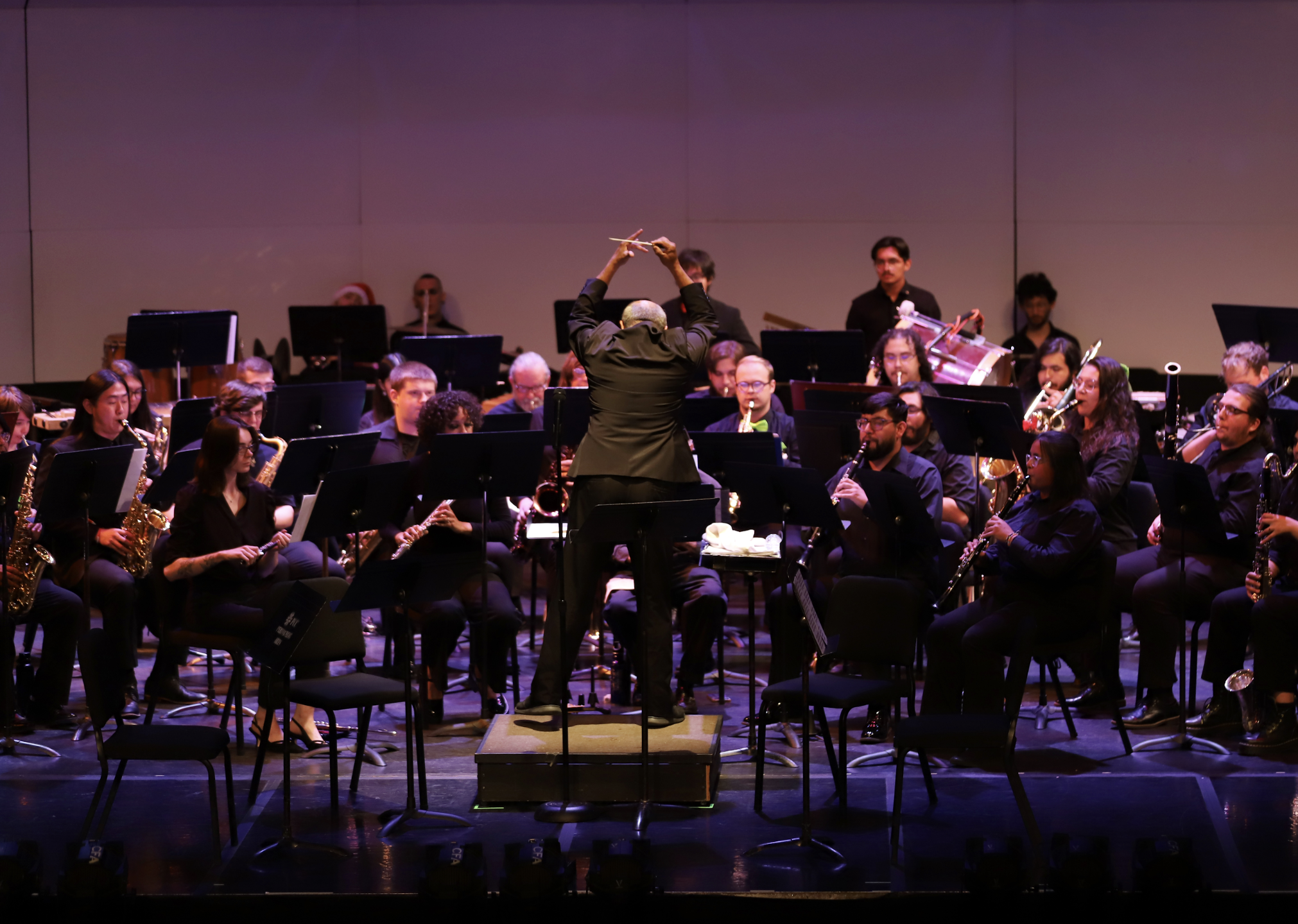 Photo of director Victor Valenzuela energetically conducting the PCC Concert band.
