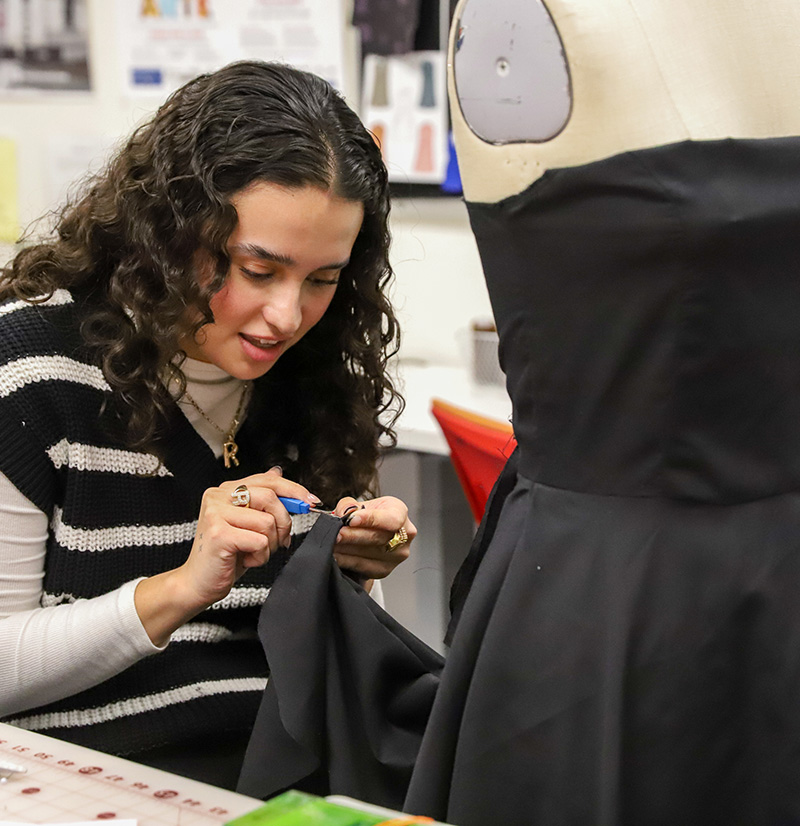A fashion design student working on a dress