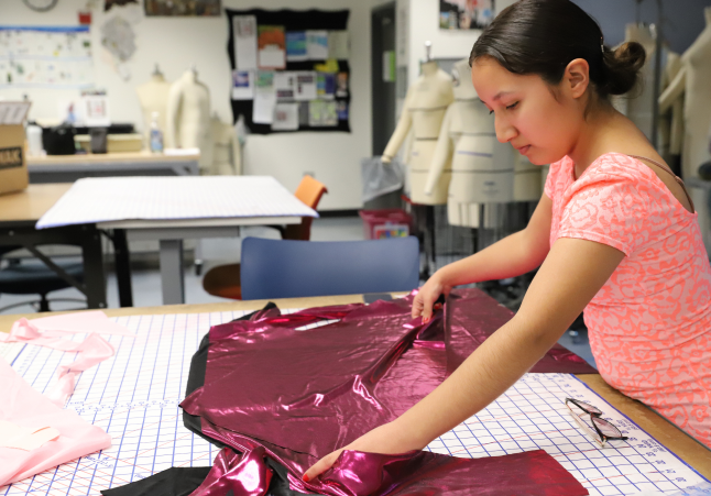 A Fashion design student taking measurements