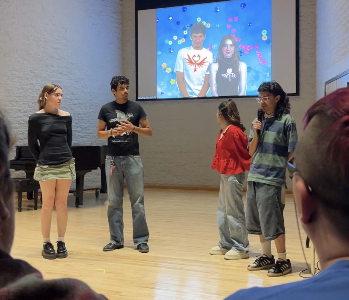 Four students explain their ARt24 entry, which is displayed on the screen behind them.